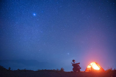 Low angle view of man standing against star field at night