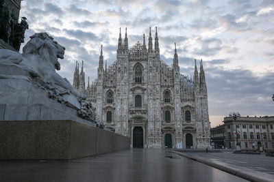 Low angle view of milan cathedral against cloudy sky at dusk