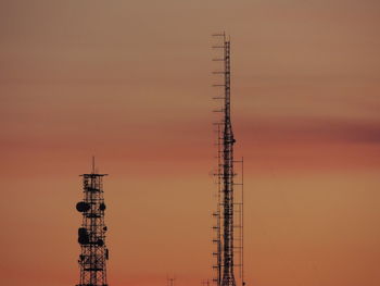 Silhouette of communications tower against sky during sunset