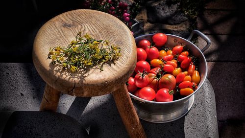Still life tomatoes and tomato blossoms on breath wooden stool