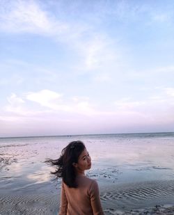 Portrait of woman on beach against sky