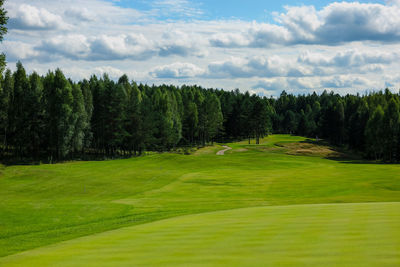 Scenic view of golf course against sky