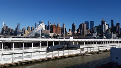 Bridge over river in city against clear sky