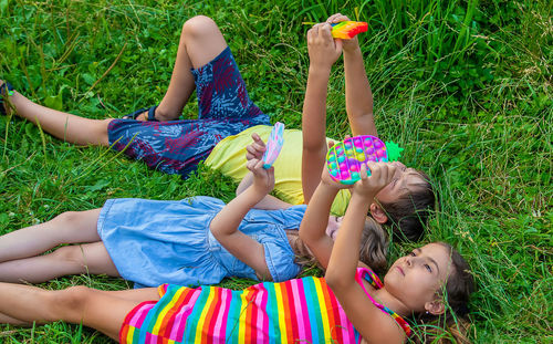 High angle view of siblings sitting on field