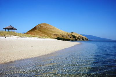 Scenic view of beach against clear blue sky