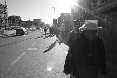 Rear view of woman with umbrella on street in city