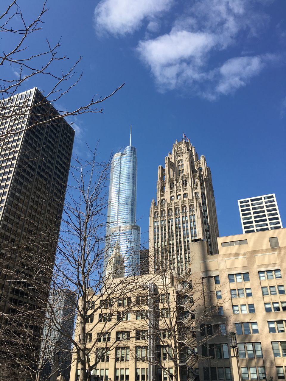 building exterior, architecture, built structure, city, low angle view, skyscraper, tall - high, modern, tower, office building, sky, glass - material, blue, building, window, day, reflection, capital cities, city life, outdoors