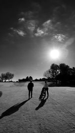 Silhouette people on street against sky