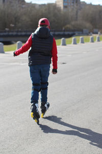 Rear view of man walking on road