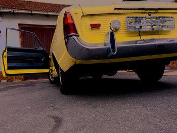 Close-up of yellow car on road