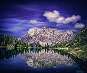 Scenic shot of calm lake with mountains in background