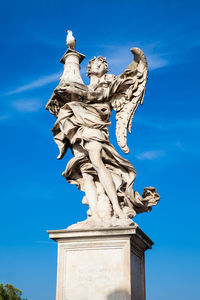 Low angle view of statue against blue sky