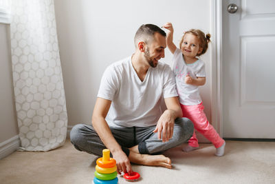 Father playing with cute daughter at home