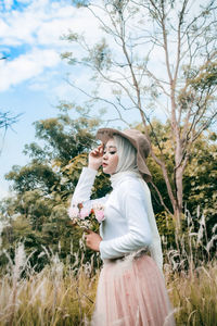 Side view of woman standing on field