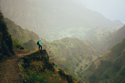 Side view of man looking at mountains