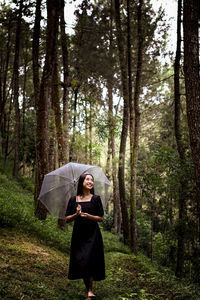 Rear view of woman standing in forest