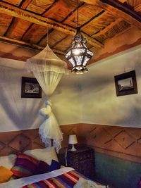 Low angle view of illuminated chandelier hanging on ceiling