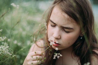 Close-up portrait of beautiful woman with red flower