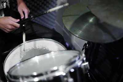 Midsection of person playing drums