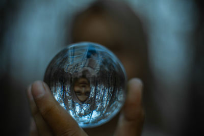 Close-up of hand holding crystal ball