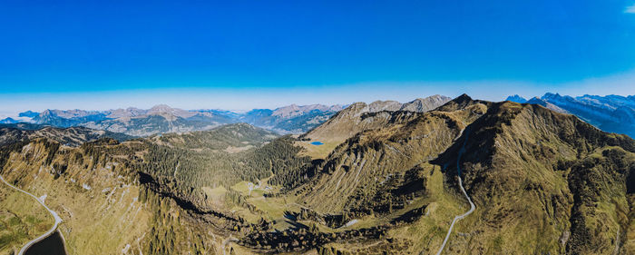 Panoramic view of mountain range against blue sky
