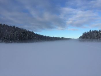 Scenic view of snow covered land against sky