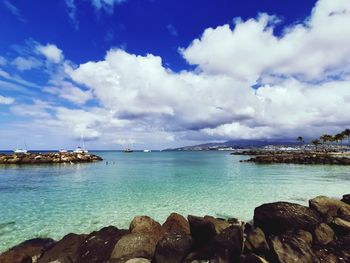 Crystal blue lagoon and cloudy sky on rocky bay