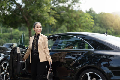 Portrait of senior man standing in car