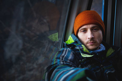 Portrait of a young man climbing to the top in the cabin of the cable car at a ski resort against