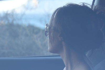 Portrait of woman looking through window