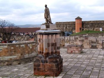 Statue of historic building against cloudy sky