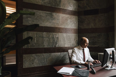 Working senior businessman using computer at law office