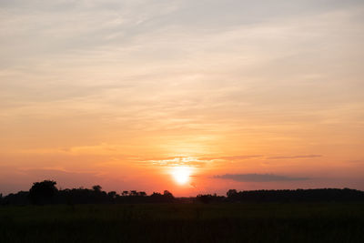 Scenic view of silhouette field against sky during sunset