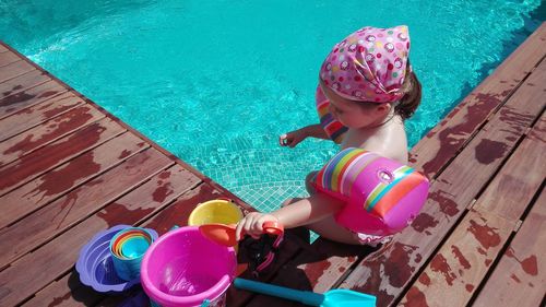 High angle view of boy sitting in swimming pool