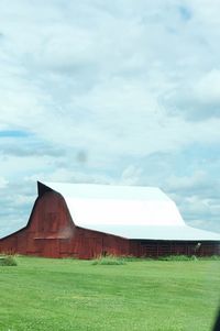 Barn on field against sky