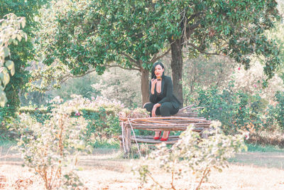 Woman sitting on wood in park