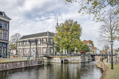 Canal amidst buildings against sky in city