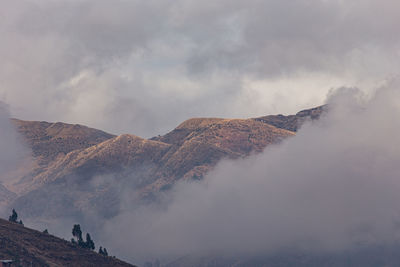 Scenic view of mountains against cloudy sky