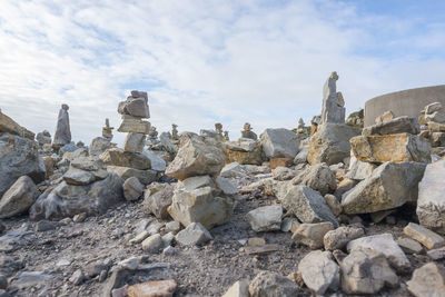 Stack of stones on rocks against sky