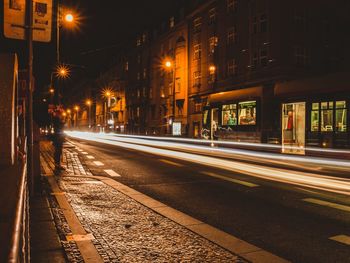 Light trails on street amidst buildings at night