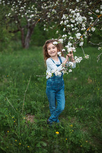 Portrait of young woman standing amidst plants