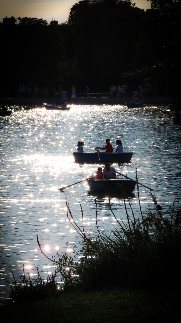 water, nautical vessel, reflection, transportation, nature, mode of transportation, men, lake, boat, evening, plant, leisure activity, adult, group of people, tree, vehicle, sitting, sky, outdoors, darkness, night, lifestyles, travel, silhouette, sunset, togetherness, light, women, holiday, vacation, trip, beauty in nature, watercraft, rowing, boating