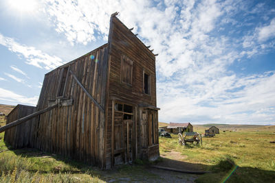 Old ruin of wild west building in ghost town on field against sky