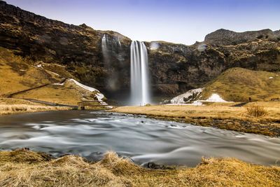 Scenic view of waterfall against sky