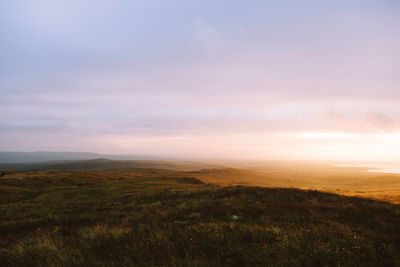 Scenic view of field against sky during sunset