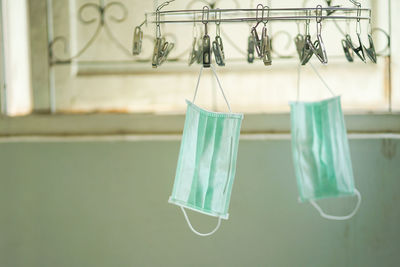 Close-up of clothes hanging on clothesline against wall