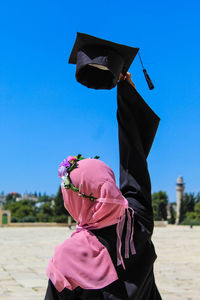 Woman with pink umbrella against clear sky