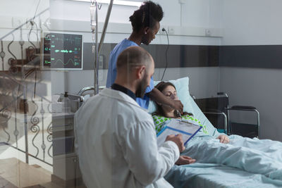 Side view of doctor examining patient at clinic