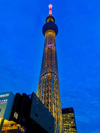 Low angle view of illuminated building against blue sky