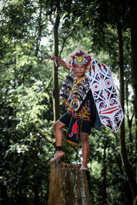 Rear view of woman standing in forest